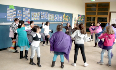 Kinder stehen im Kreis und tanzen.