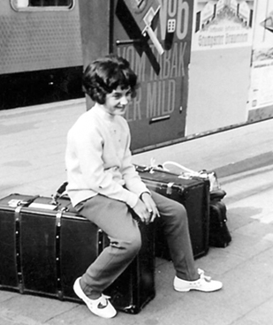 Kind sitzt auf Koffer