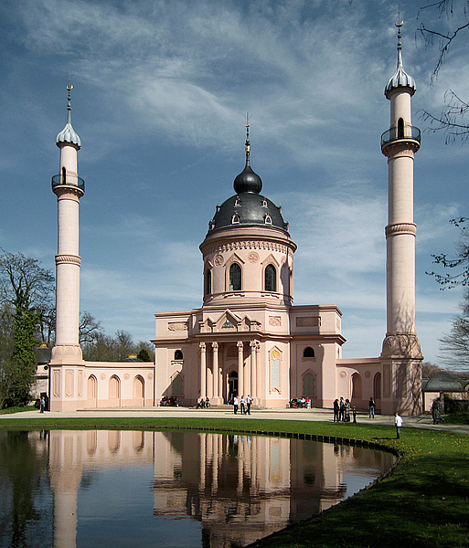 Ansicht der Roten Moschee, davor ein angelegter Teich und Menschen