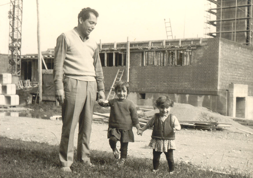 Türkischer Vater mit seinen zwei jungen Mädchen vor Baustelle